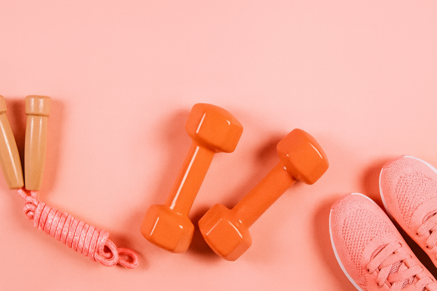 Dumbbells and Athletic Shoes on Pink Background